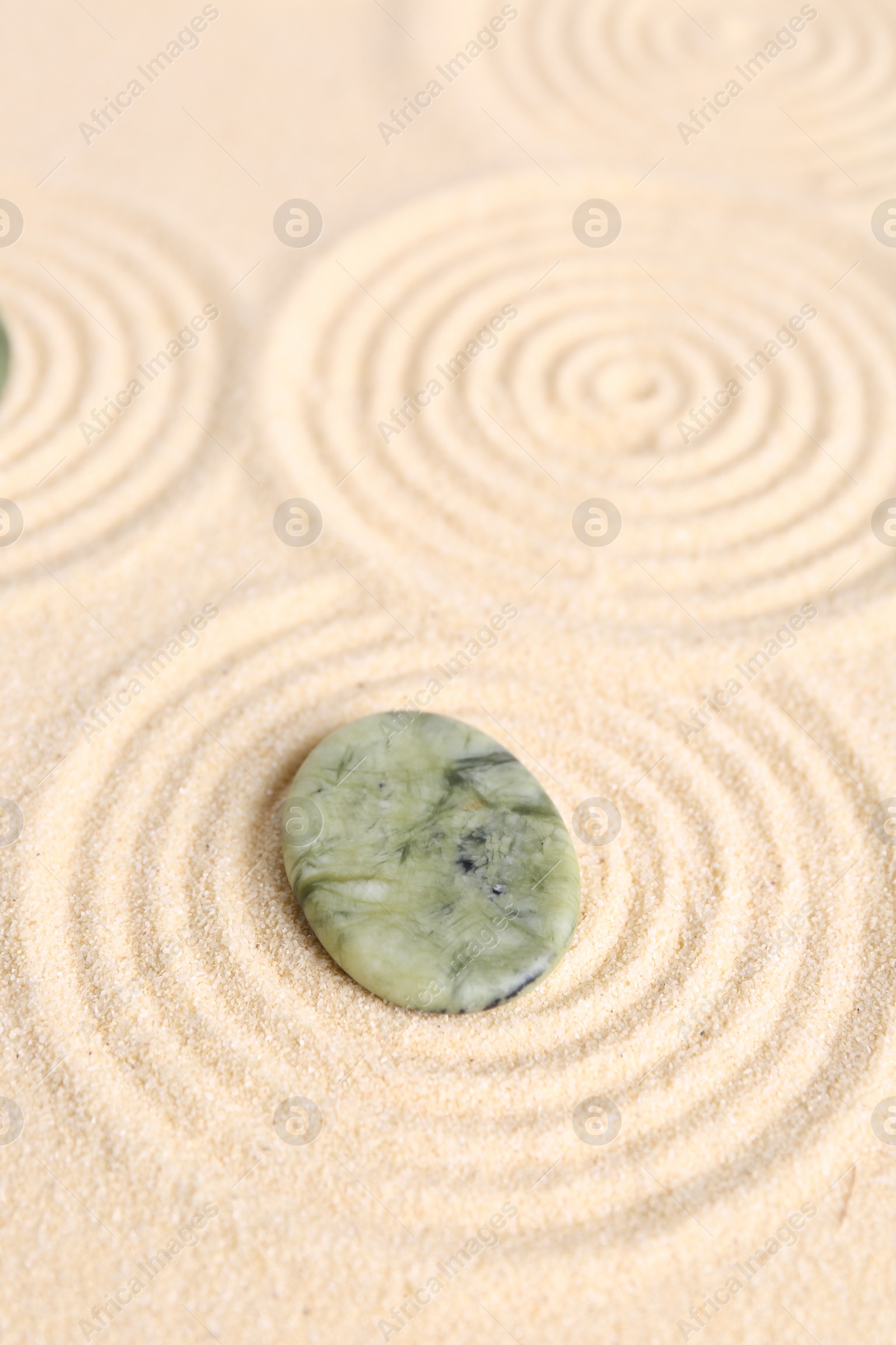 Photo of Zen garden stone on beige sand with pattern