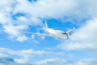 Image of Airplane flying in blue sky with clouds. Air transportation