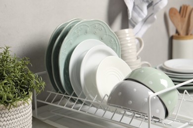 Many different clean dishware and houseplant on white table indoors