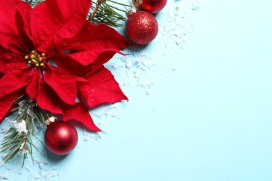 Photo of Flat lay composition with poinsettia and space for text on color background. Traditional Christmas flower