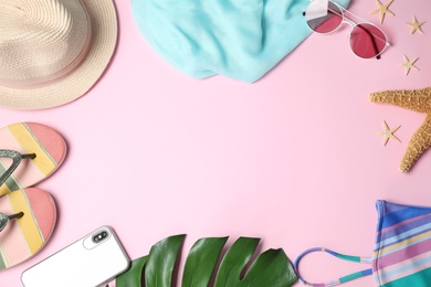 Flat lay composition with beach accessories on pink background, space for text