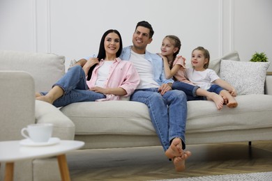 Happy family resting on comfortable sofa in living room