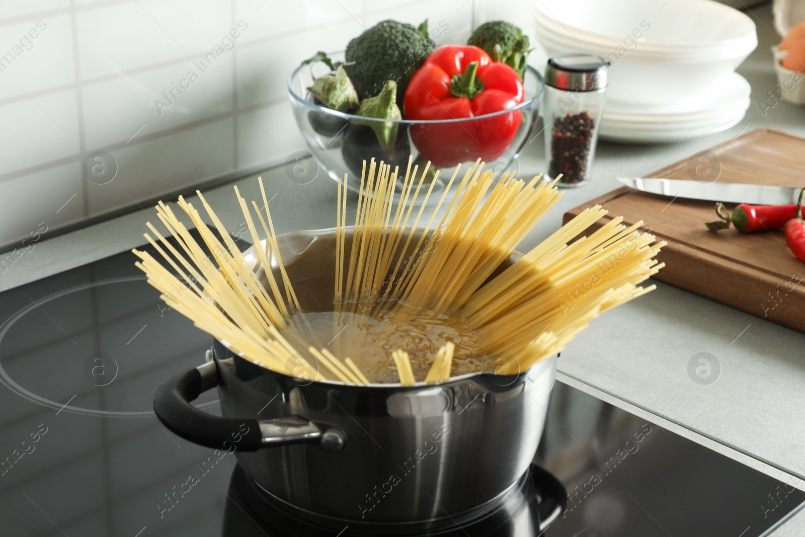 Photo of Cooking spaghetti in pot on electric stove