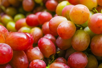 Fresh ripe juicy red grapes as background, closeup view