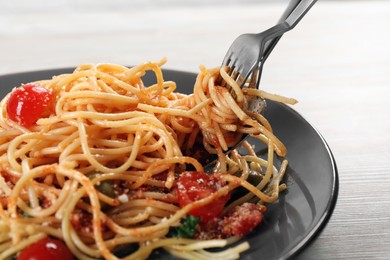 Photo of Eating delicious pasta with tomatoes and parmesan cheese at white wooden table, closeup