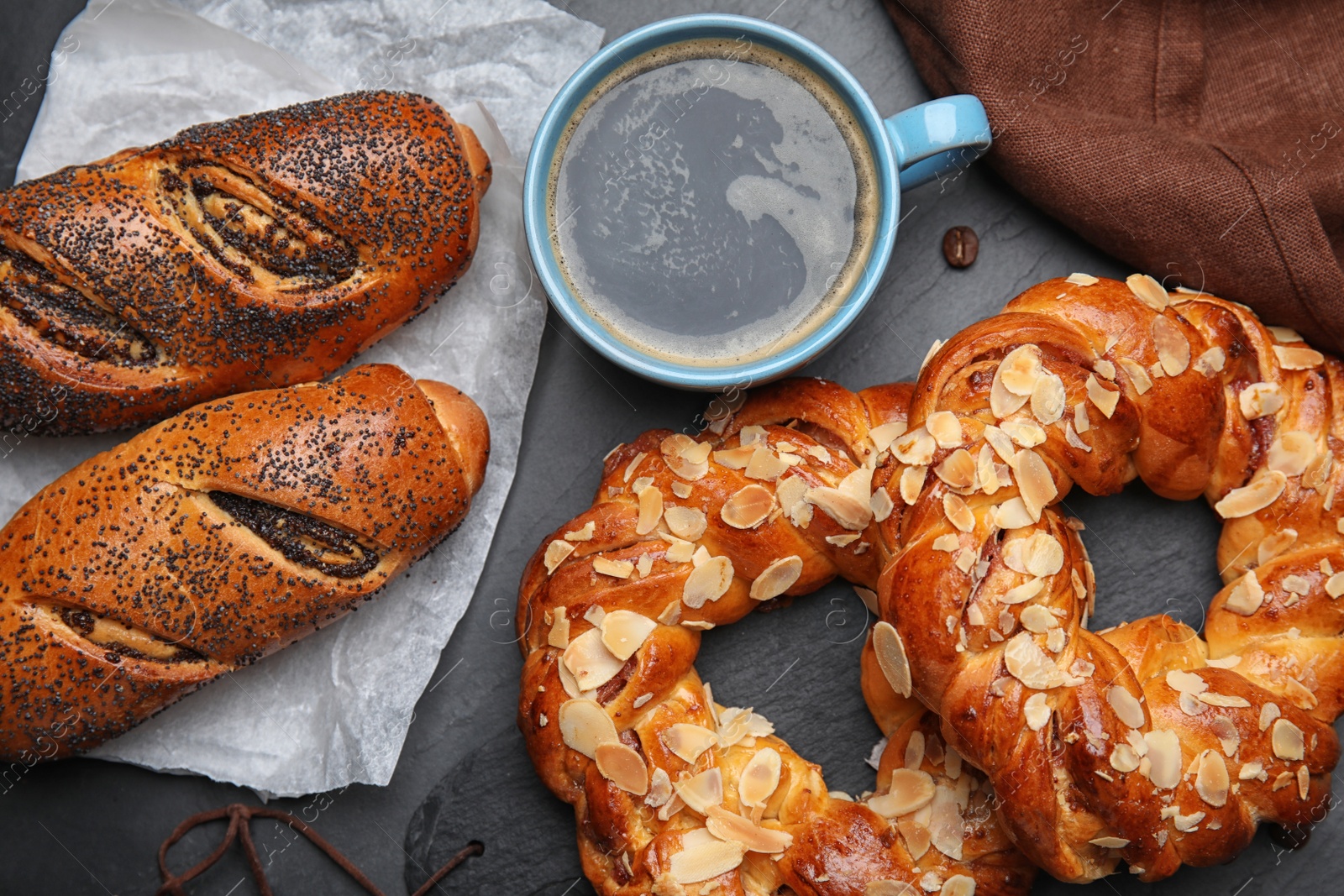 Photo of Delicious pastries and coffee on black table, flat lay