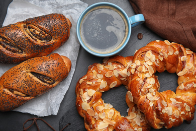 Delicious pastries and coffee on black table, flat lay