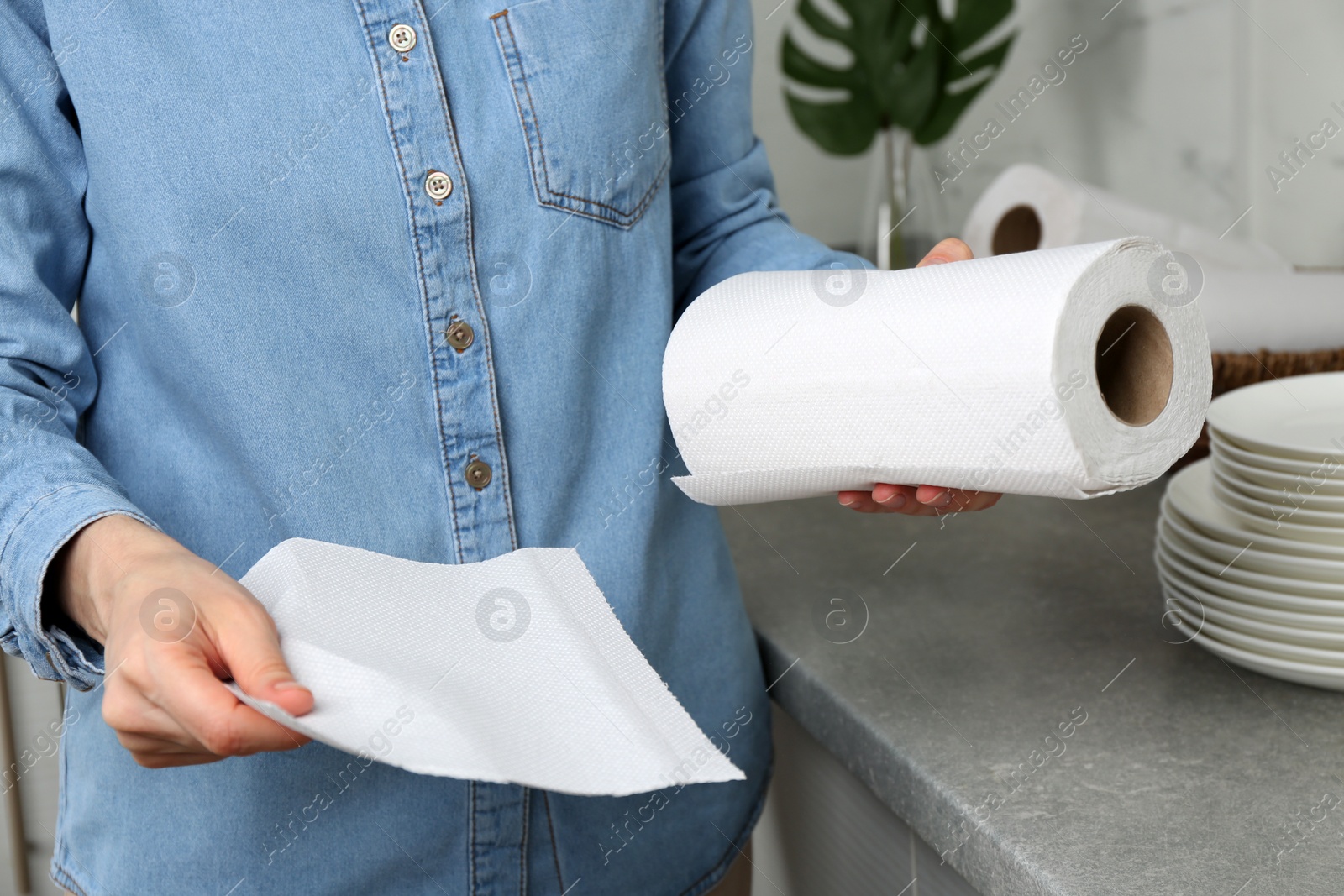 Photo of Woman using paper towels in kitchen, closeup