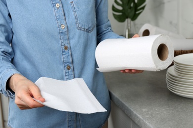 Woman using paper towels in kitchen, closeup