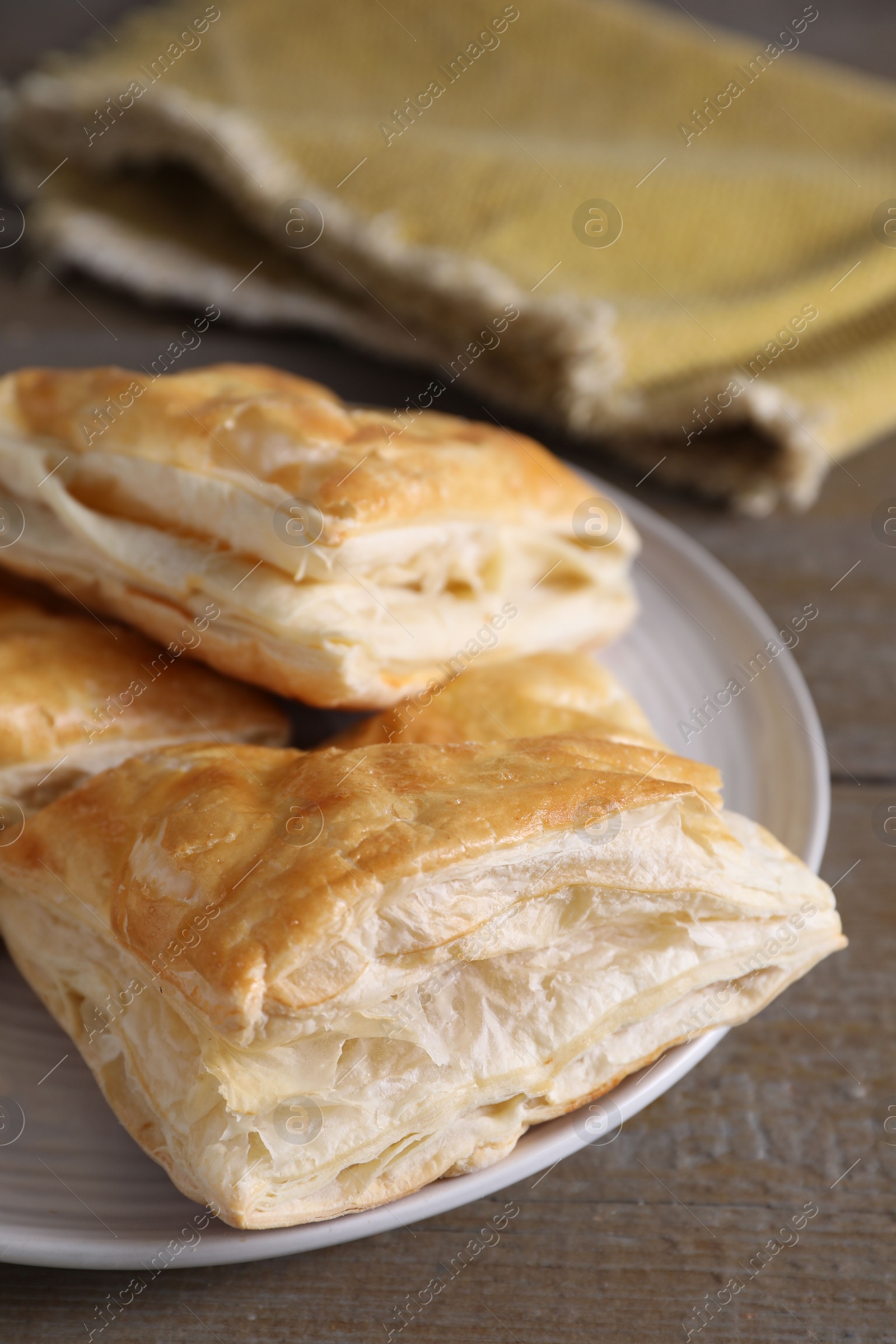 Photo of Delicious fresh puff pastries on wooden table, closeup