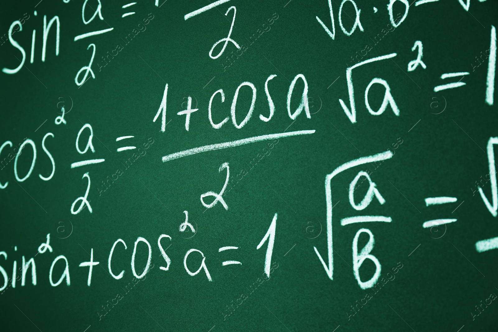 Photo of Many different math formulas written on chalkboard, closeup