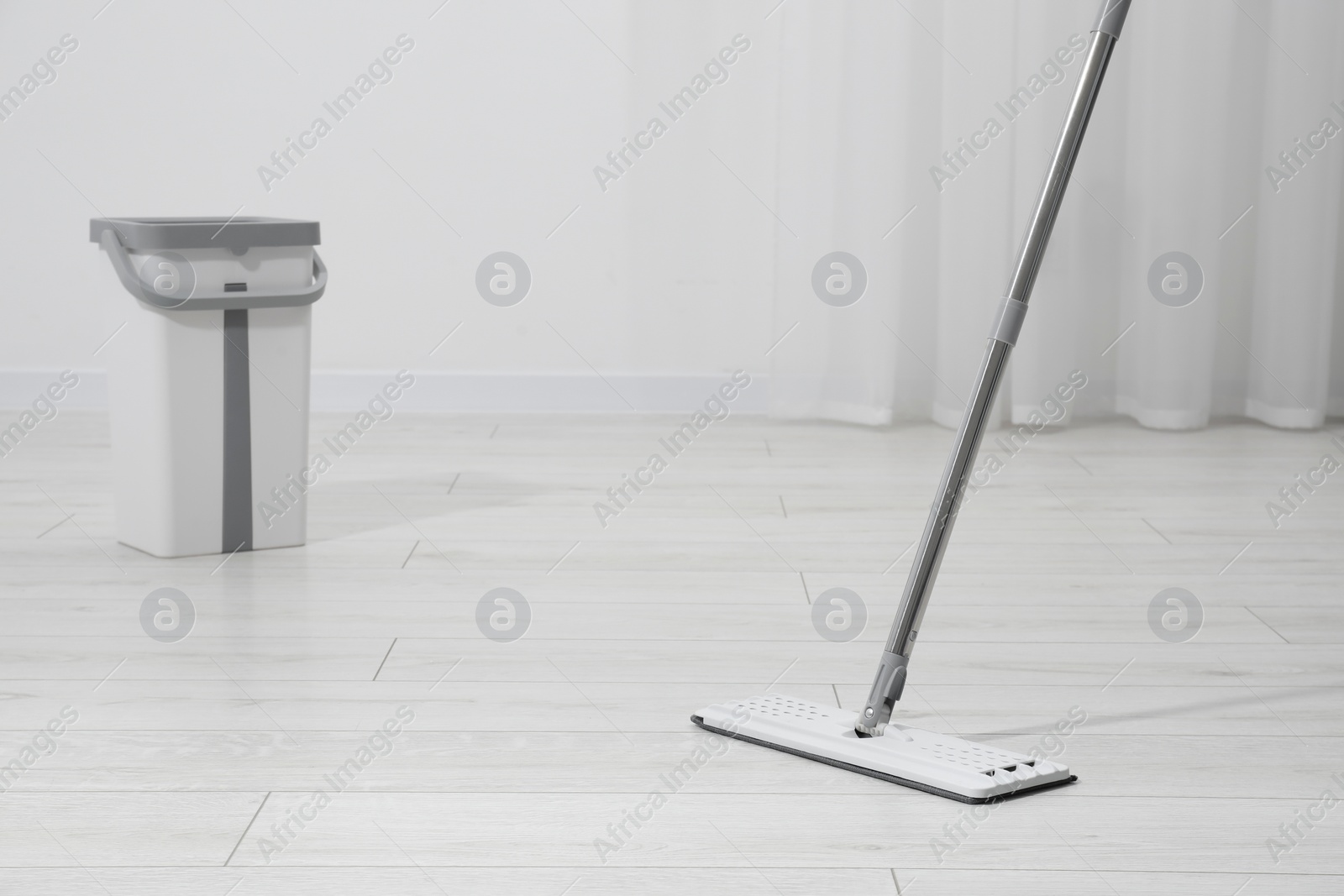 Photo of Cleaning dirty parquet floor with mop indoors. Space for text