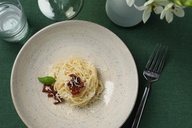 Photo of Tasty spaghetti with sun-dried tomatoes and cheese on table, flat lay. Exquisite presentation of pasta dish