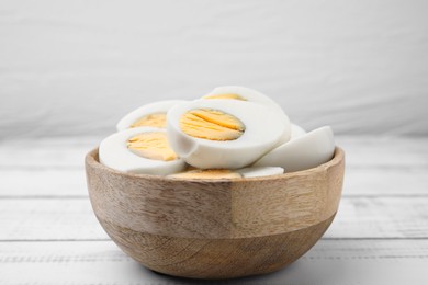 Photo of Bowl of fresh hard boiled eggs on white wooden table