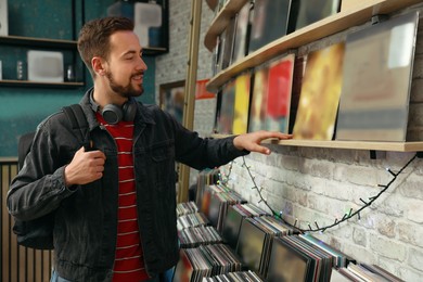 Image of Young man choosing vinyl records in store