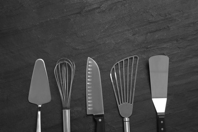 Cooking utensils on black table, flat lay