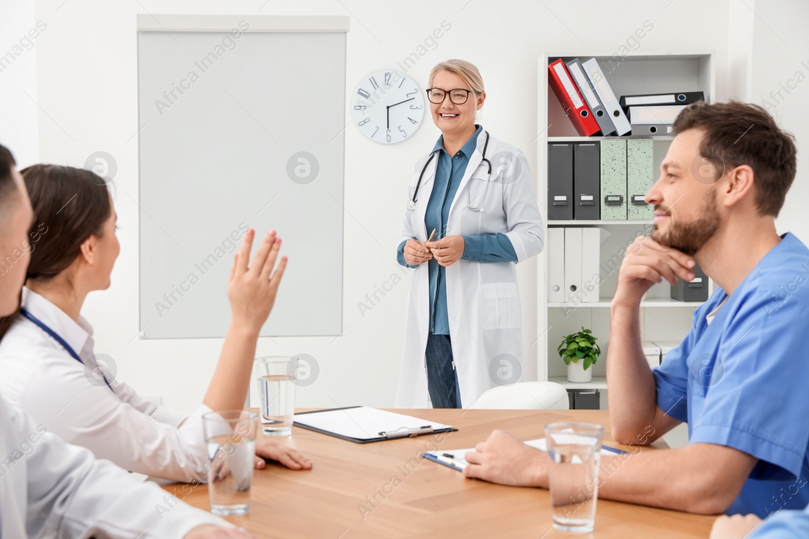 Photo of Doctor giving lecture near flipchart in conference room