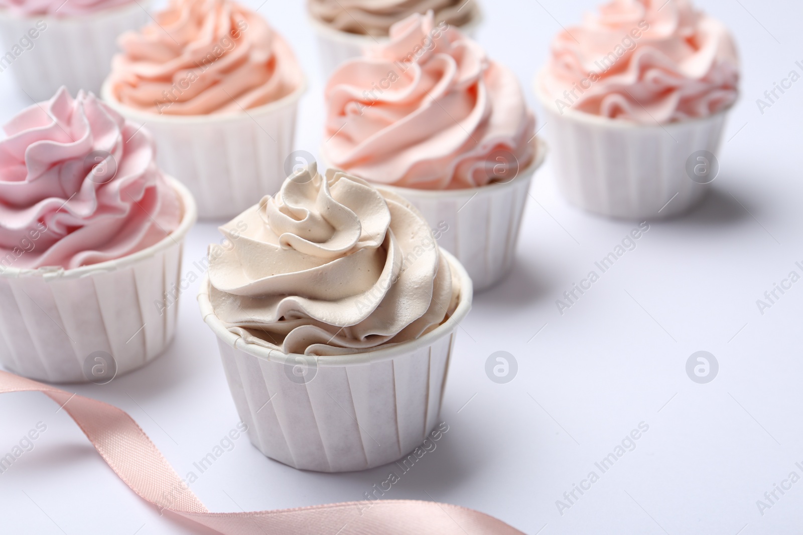 Photo of Many tasty cupcakes on white background, closeup