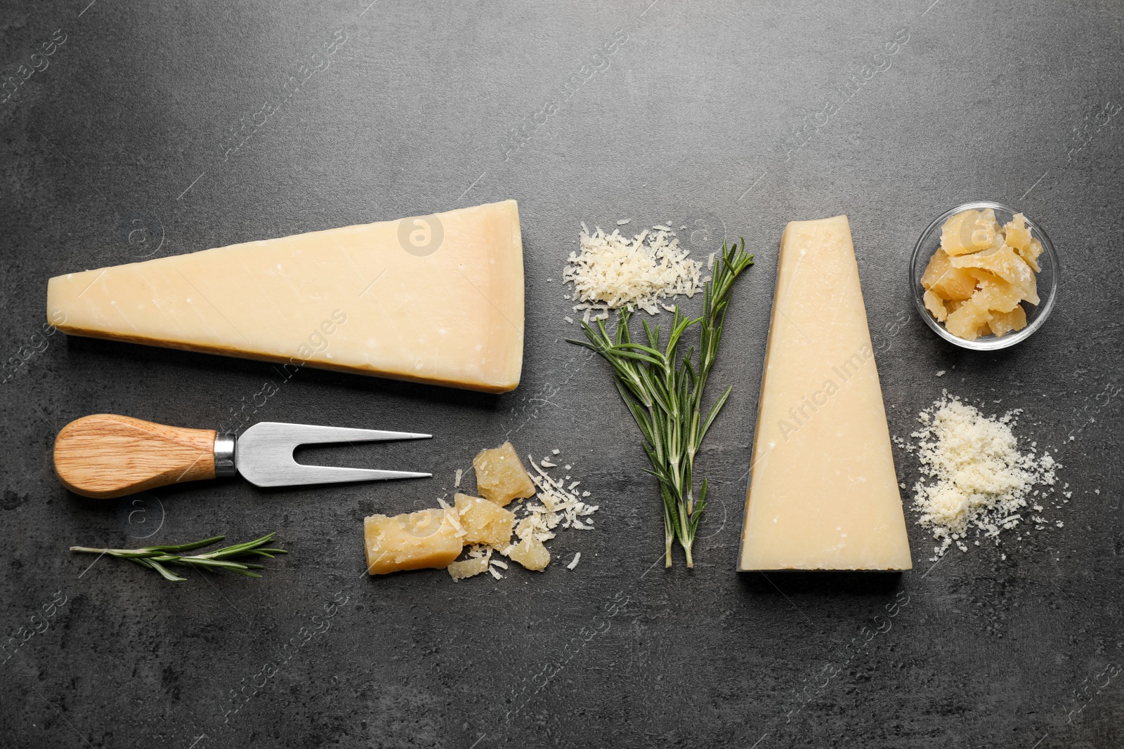 Photo of Flat lay composition with delicious Parmesan cheese on dark grey table