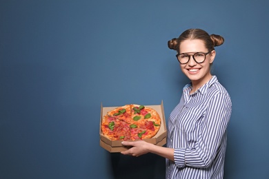 Attractive young woman with delicious pizza on color background