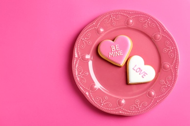 Photo of Plate with decorated heart shaped cookies and space for text on color background, top view. Valentine's day treat