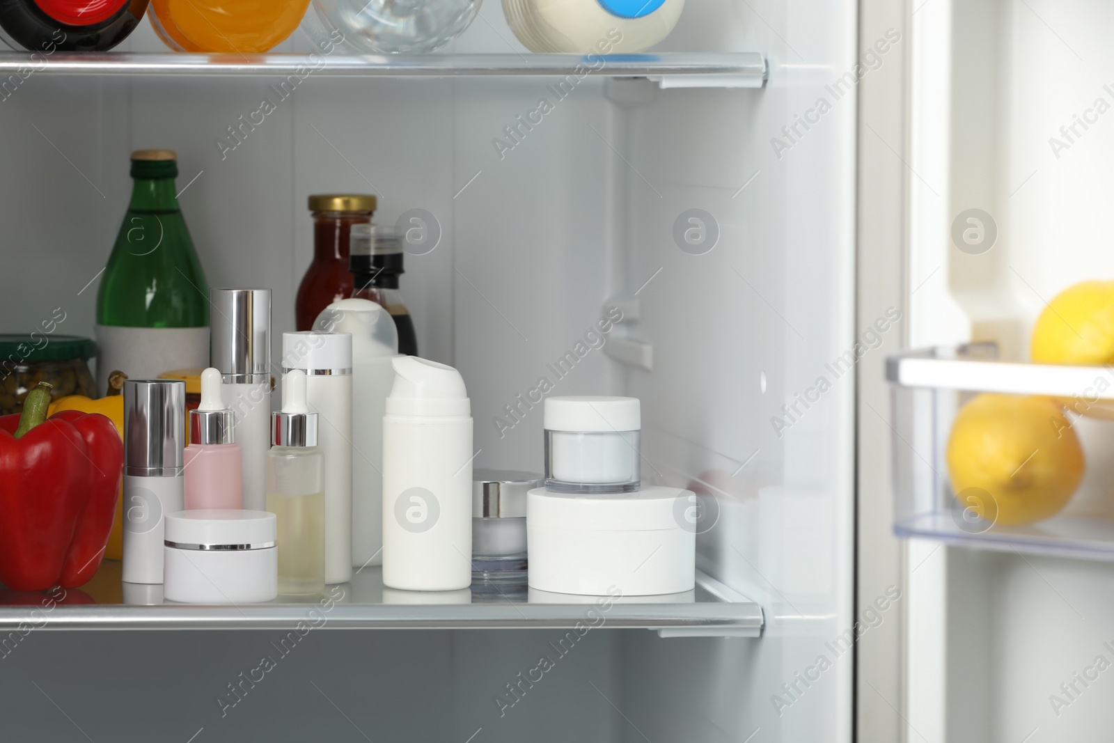 Photo of Different cosmetic products on shelf in refrigerator