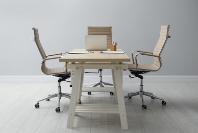 Photo of Director's office with large wooden table and comfortable armchairs. Interior design