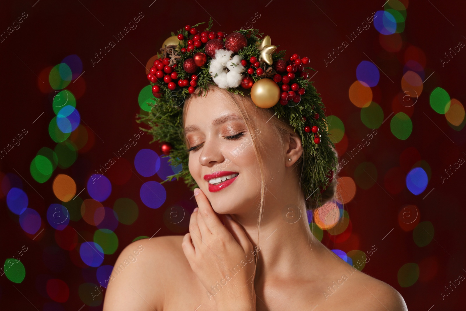 Photo of Beautiful young woman wearing Christmas wreath on blurred background. Bokeh effect