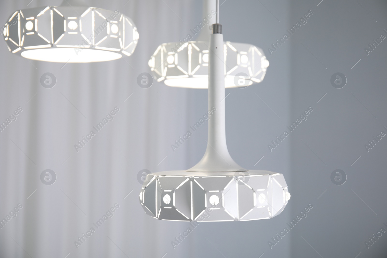 Photo of Stylish white pendant lamp in light room