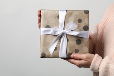 Photo of Christmas present. Woman holding gift box against white background, closeup. Space for text