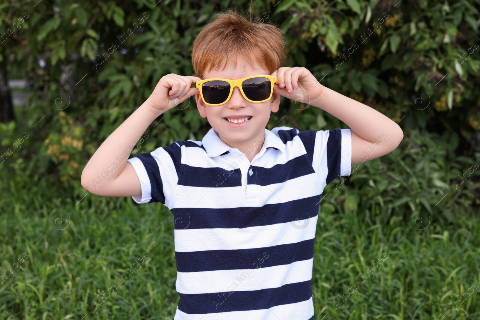 Photo of Cute little boy with sunglasses in park