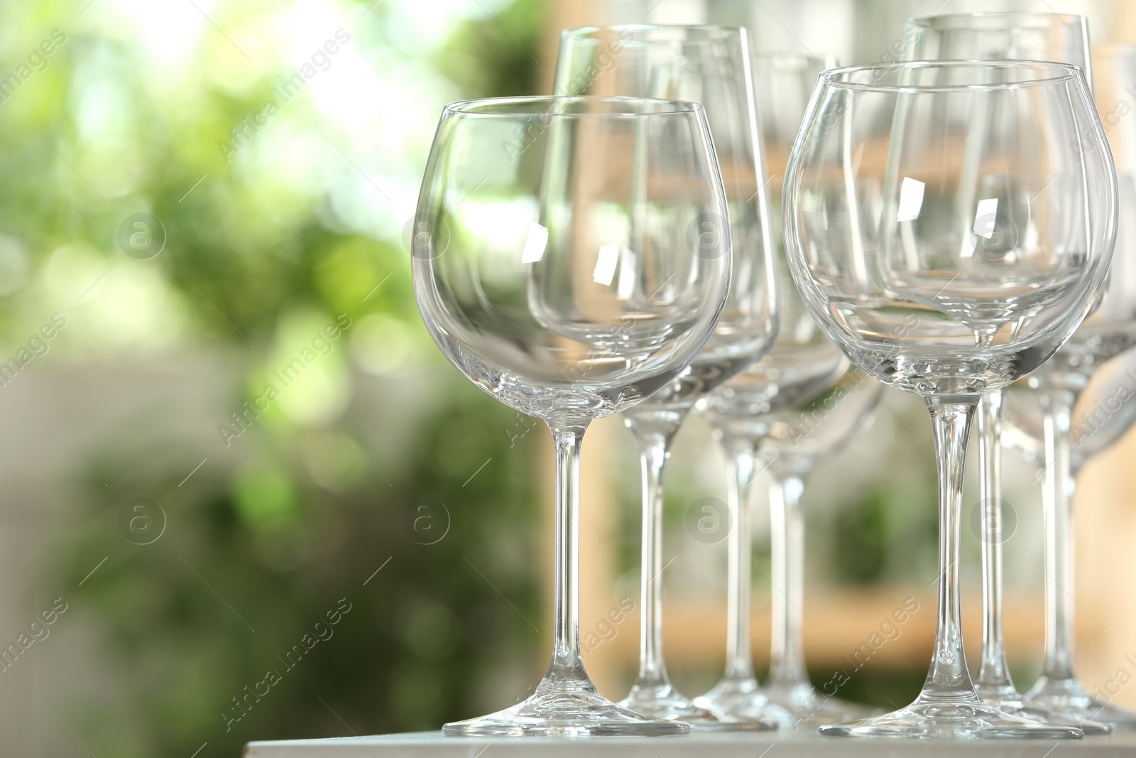 Photo of Empty glasses on table against blurred background