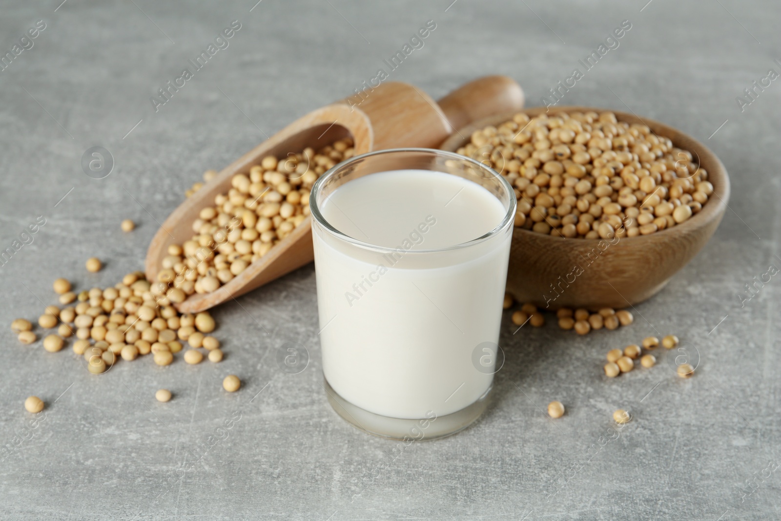 Photo of Glass with fresh soy milk and grains on grey table
