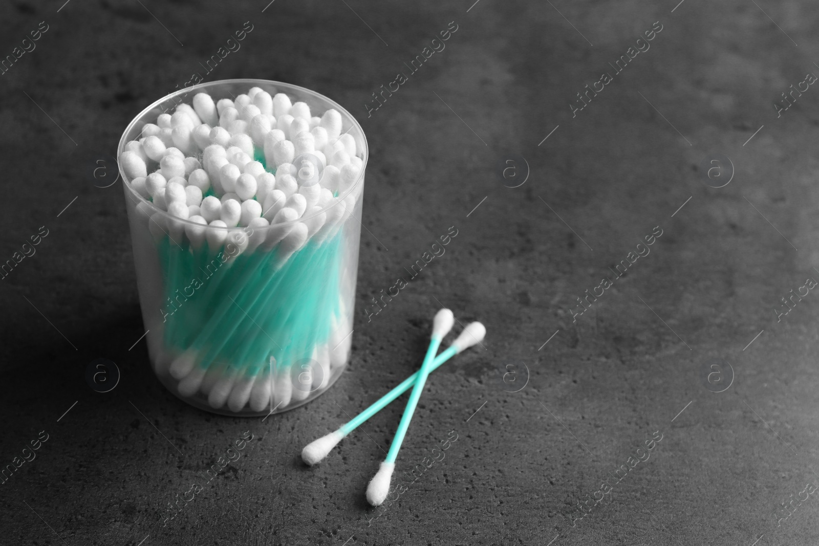 Photo of Plastic container with cotton swabs on grey background. Space for text