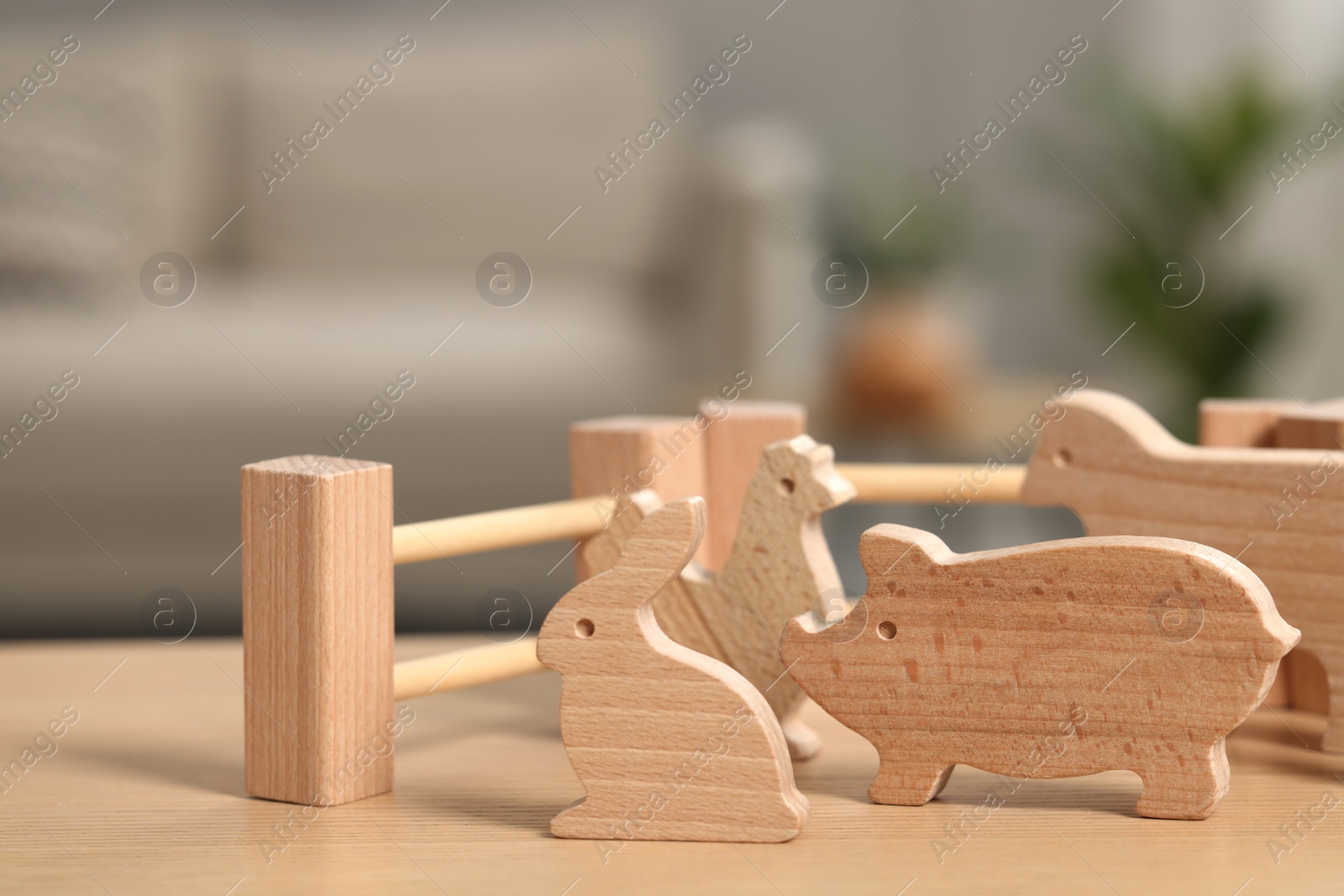 Photo of Wooden animals and fence on table indoors, closeup. Children's toys