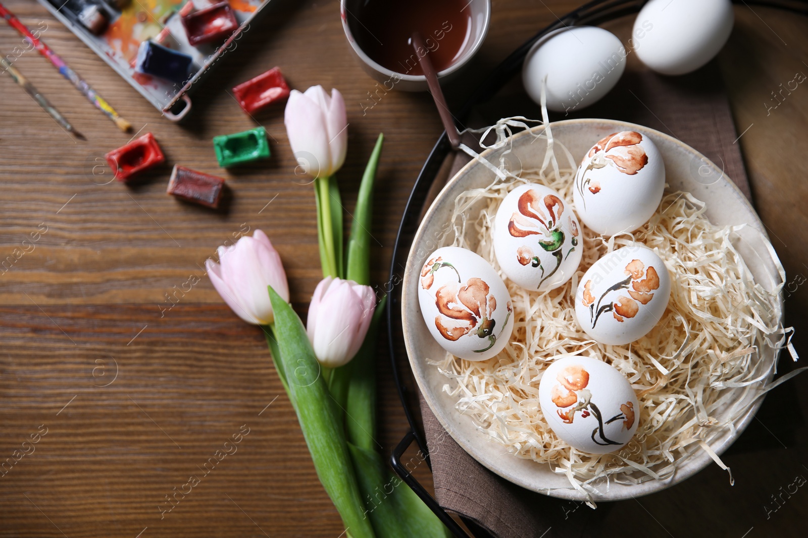 Photo of Flat lay composition with painted Easter eggs on wooden table, space for text