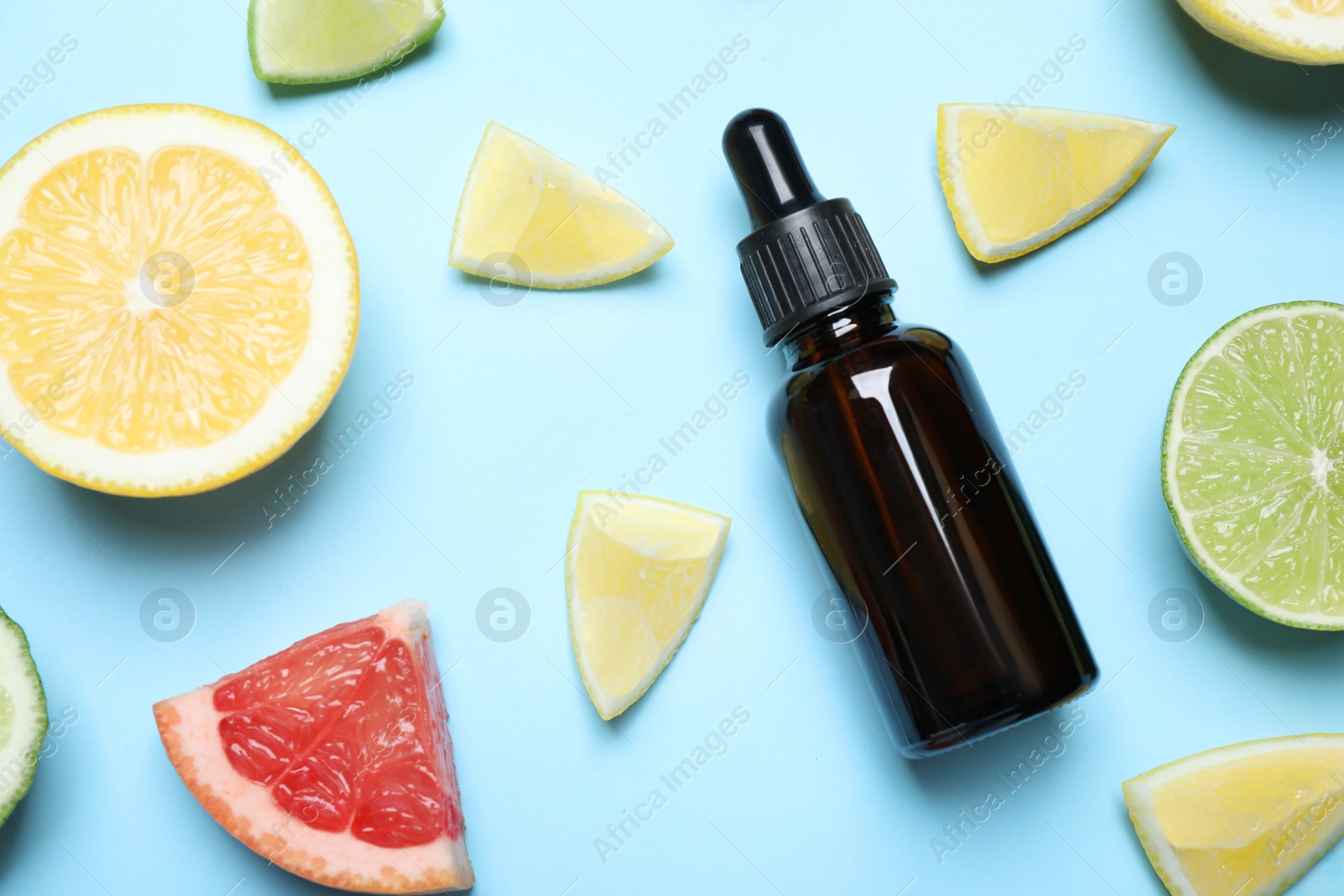 Photo of Flat lay composition with citrus essential oil on light blue background