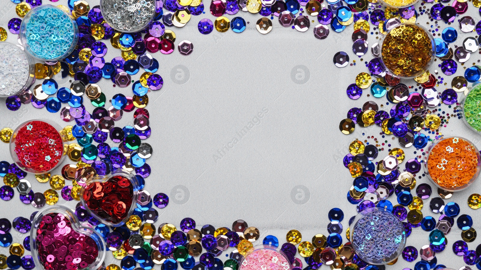 Photo of Frame of many different shiny colorful sequins on light grey background, flat lay. Space for text