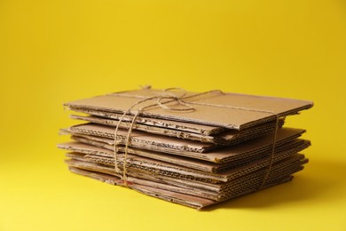 Photo of Waste paper tied with twine on yellow background