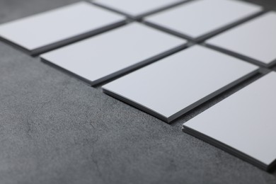 Photo of Blank business cards on grey textured table, closeup. Mockup for design