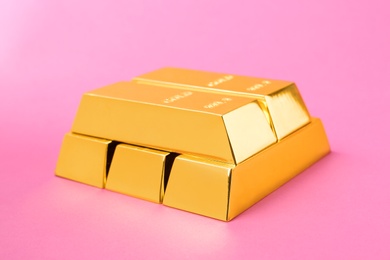 Precious shiny gold bars on color background