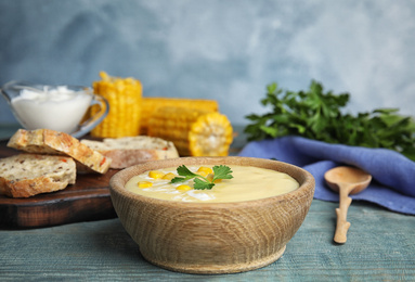 Delicious corn cream soup served on wooden table