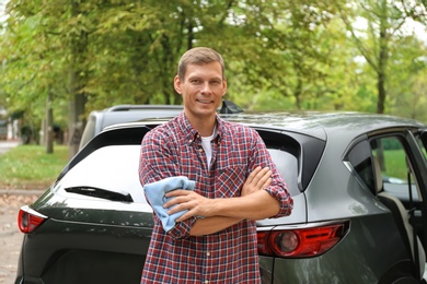 Man with rug near washed car outdoors