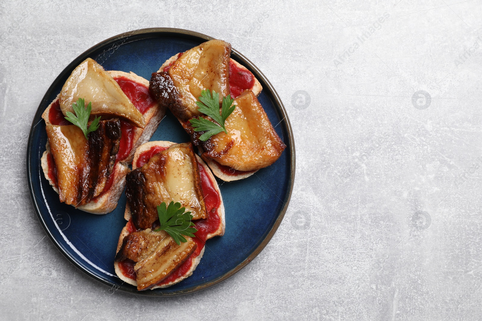 Photo of Tasty sandwiches with fried pork fatback slices on light grey table, top view. Space for text