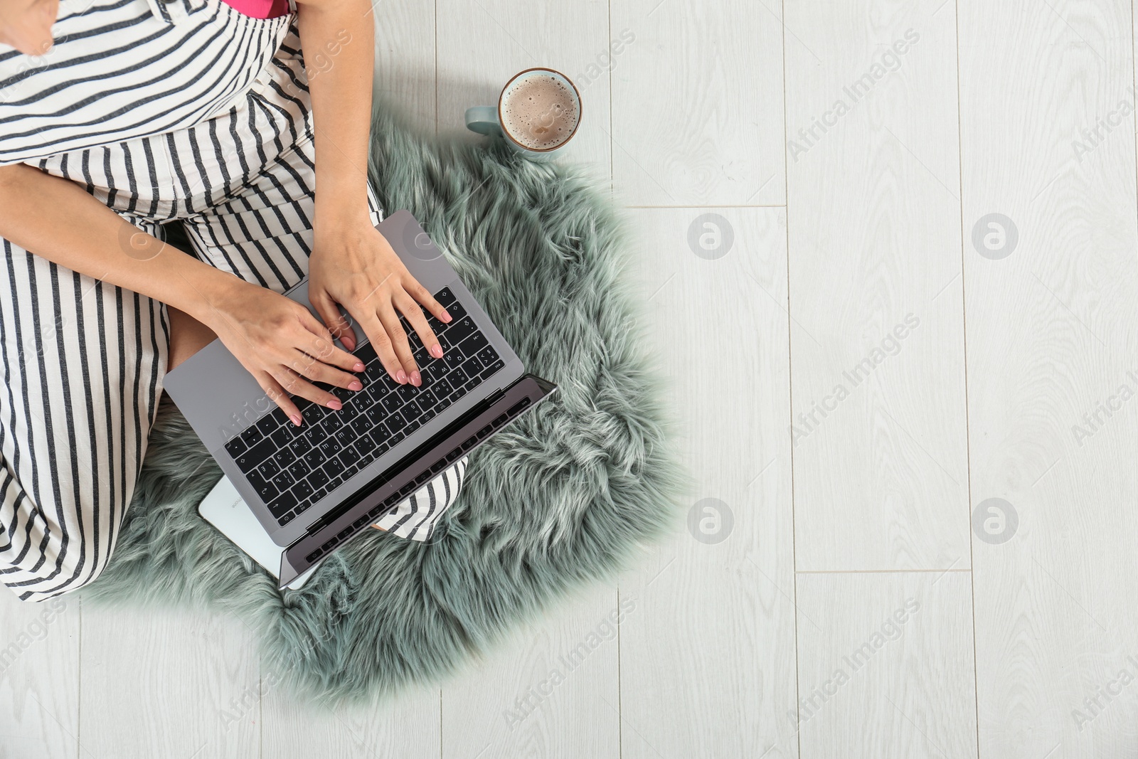 Photo of Young woman with laptop sitting on floor, top view