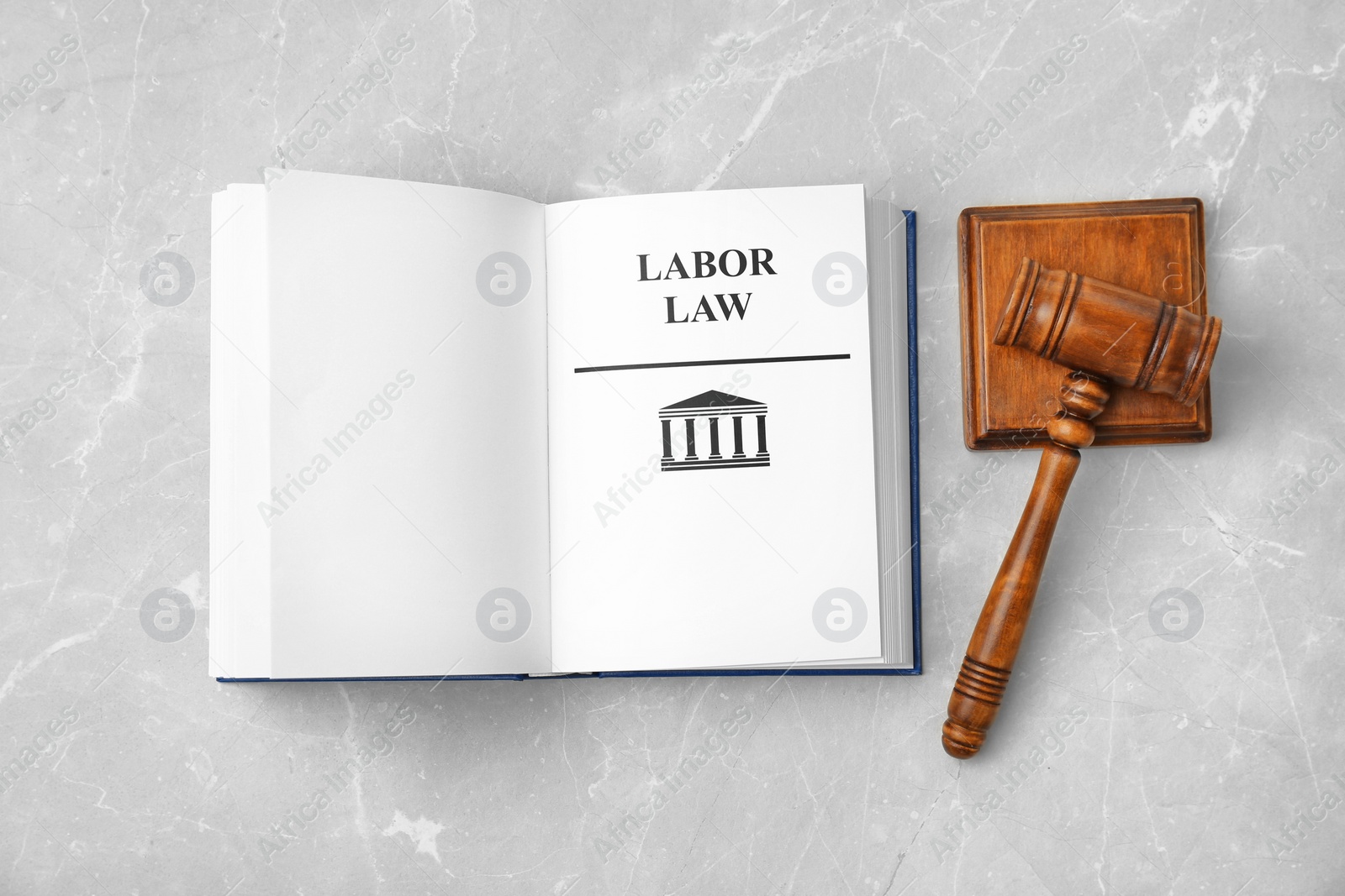 Photo of Open book with words LABOR LAW and gavel on light background, top view