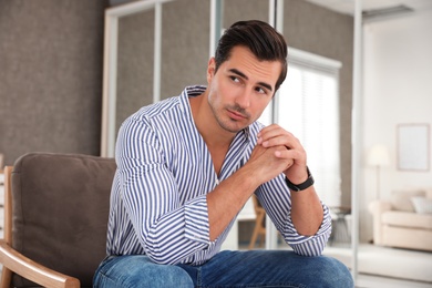 Photo of Portrait on handsome young man sitting in chair indoors