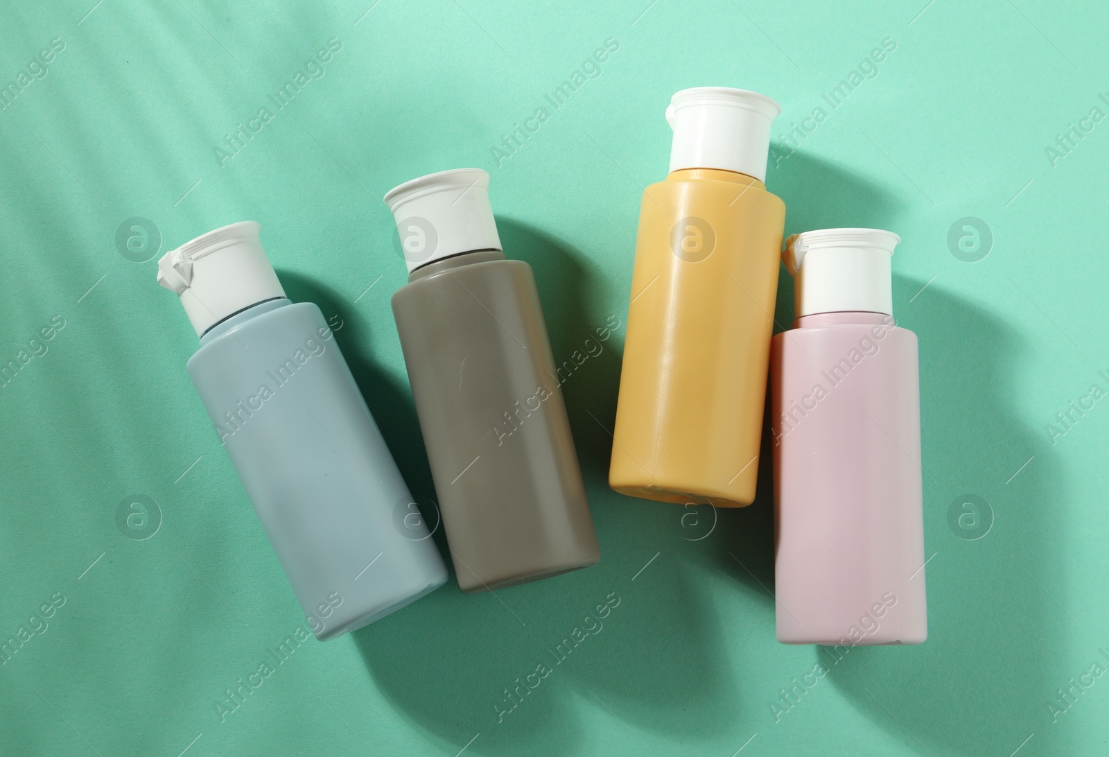 Photo of Cosmetic travel kit on turquoise background, top view