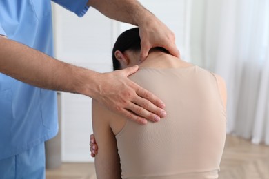 Photo of Orthopedist examining woman in clinic, closeup. Scoliosis treatment