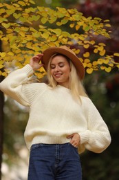 Photo of Portrait of happy woman wearing warm sweater in autumn park